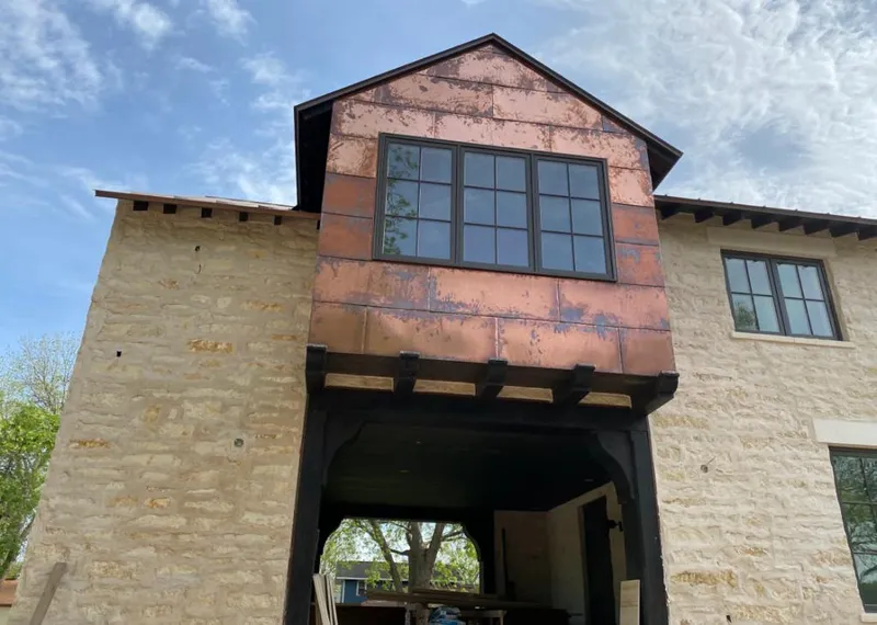 Copper metal panel facade on a stone building for Roof Repair in Lapeer
