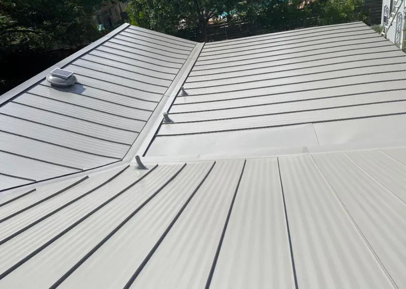 Solar attic fan installed on a metal roof for Roof Ventilation in Lapeer